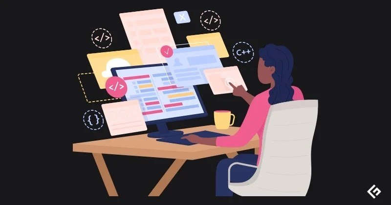 Software developer writing code on a monitor in a dark office