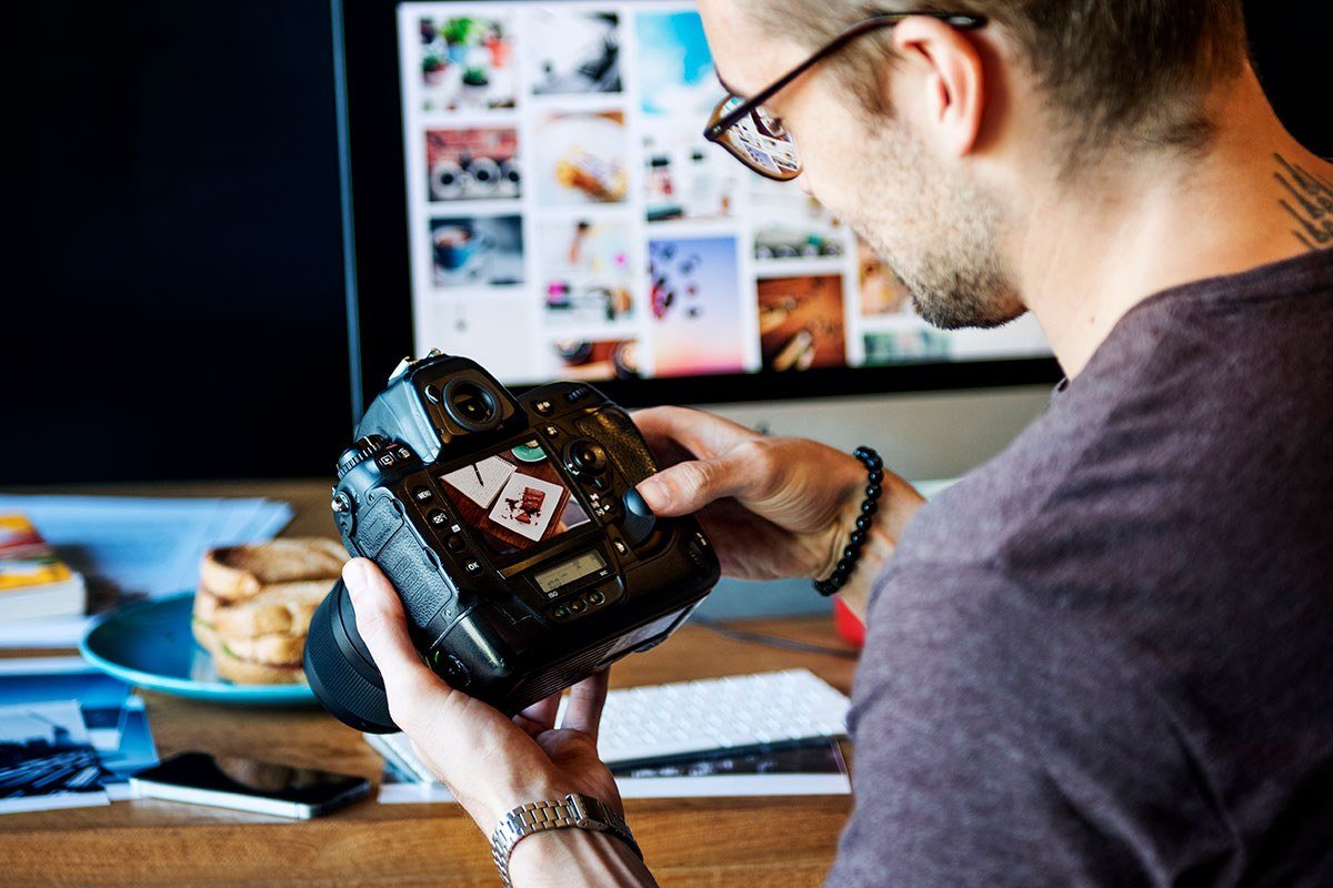 Photographer editing photos with AI tools on a computer screen