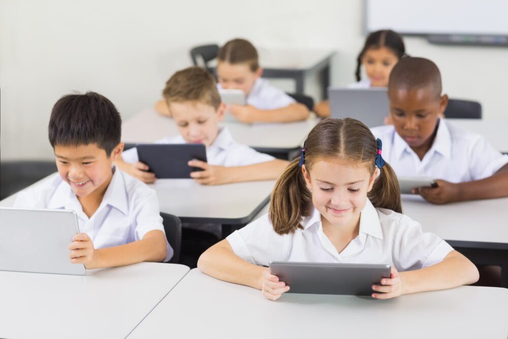 School classroom with kids learning using tablets and technology